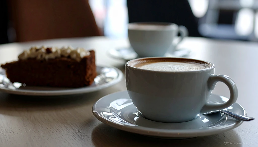 テーブルに並べられた2つのコーヒーカップとケーキ。